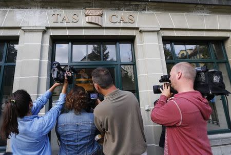 Members of the media film the arrival of Uruguayan striker Luis Suarez for an hearing at the Court of Arbitration for Sport (CAS) in Lausanne August 8, 2014. REUTERS/Denis Balibouse