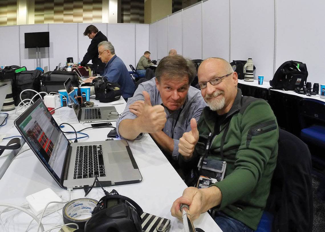 News & Observer photojournalist Robert Willett and Chuck Liddy (right) work from the press area at a college basketball tournament.