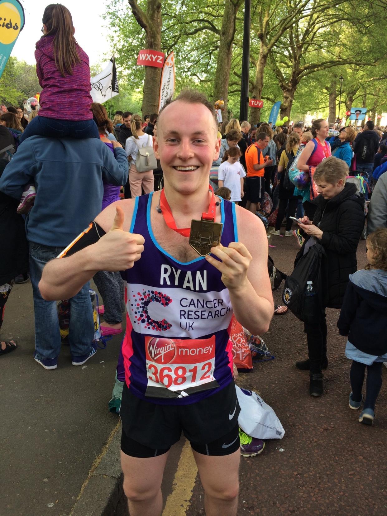 Man holds medal after racing marathon