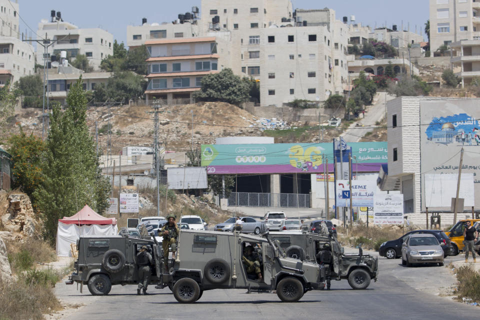 Israeli forces close the roads near the area of an attack, west of the West Bank city of Ramallah, Friday, Aug. 23. 2019. An explosion Friday near a West Bank settlement that Israel said was a Palestinian attack killed a 17-year-old Israeli girl and wounded her brother and father, Israeli authorities said. (AP Photo/Nasser Nasser)