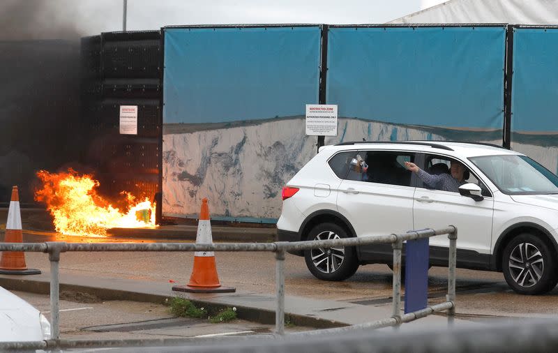 A man throws an object out of a car window next to the Border Force centre after a firebomb attack in Dover