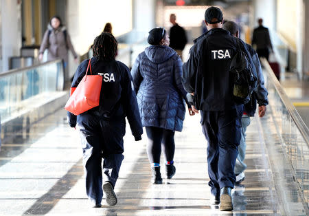 FILE PHOTO: Employees with the Transportation Security Administration (TSA) walk through Reagan National Airport in Washington, U.S., January 6, 2019. REUTERS/Joshua Roberts/File Photo