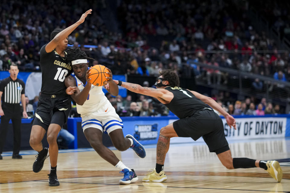 Colorado forward Cody Williams, left, Boise State forward O'Mar Stanley, middle, drives to the basket against Colorado guard J'Vonne Hadley, right, during the first half of a First Four game in the NCAA men's college basketball tournament Wednesday, March 20, 2024, in Dayton, Ohio. (AP Photo/Aaron Doster)