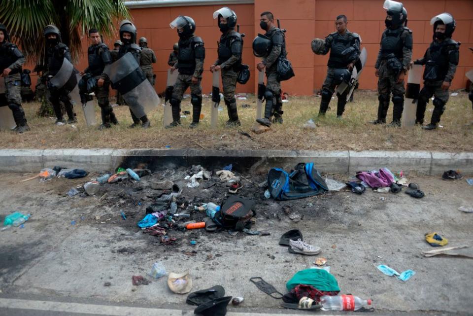 Belongings of Honduran migrants remain next to soldiers of Guatemalan Army after a violent clash. Source: Getty