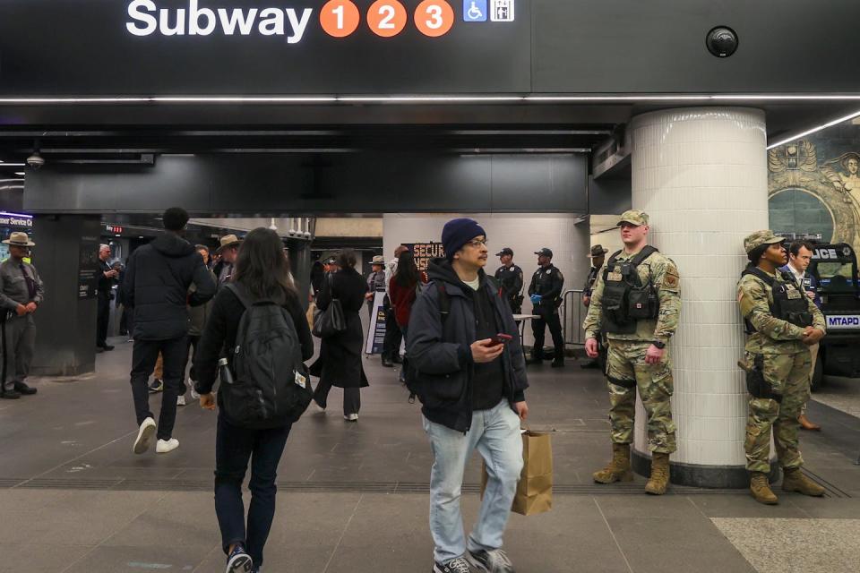 Truppen der Nationalgarde überwachen eine kleine Menge Pendler an einer New Yorker U-Bahn-Station