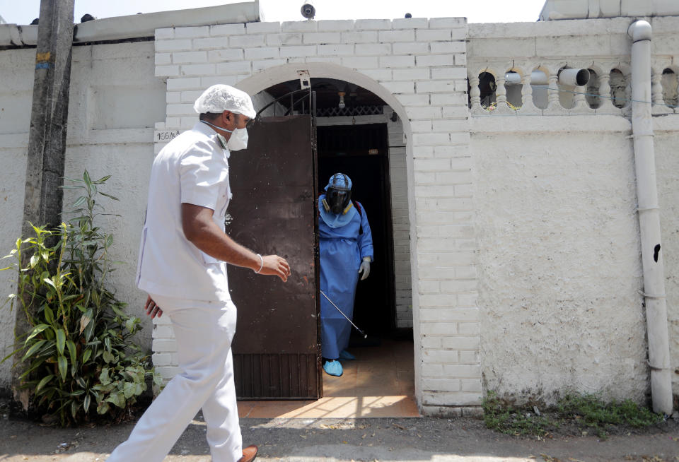 A Sri Lankan health worker sprays disinfectant inside a house in a residential neighborhood where a suspected COVID-19 case was reported in Colombo, Sri Lanka, Saturday, March 14, 2020. For most people, the new coronavirus causes only mild or moderate symptoms. For some, it can cause more severe illness, especially in older adults and people with existing health problems. (AP Photo/Eranga Jayawardena)