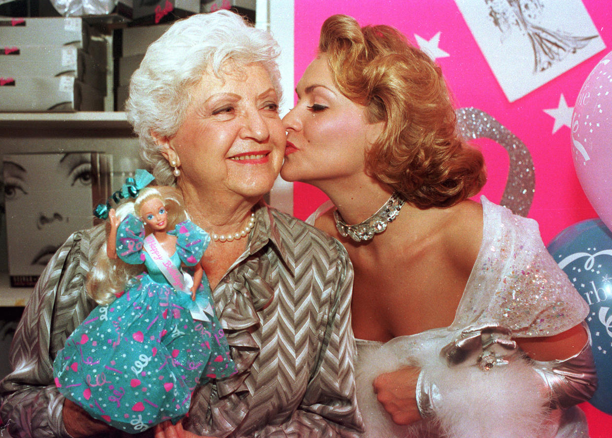 Barbie doll creator Ruth Handler, left, gets a kiss from Kristi Cooke, an actress dressed as a Barbie doll, during the 35th birthday celebration for the doll at FAO Schwarz in New York City on March 9, 1994.  (AP Photo/Robert Clark)