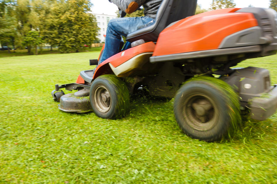 the lawn mower drives through a green meadow - used to illustrate the man who was charged with drink driving while on a lawmower