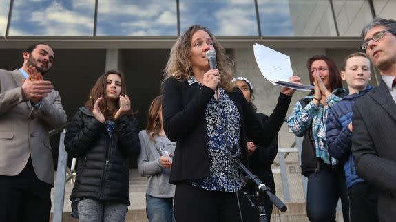 Julia Olson, center, executive director of Our Children’s Trust, holds a copy of U.S. District Judge Ann Aiken’s decision on Nov. 10, 2016, in Eugene, Oregon.