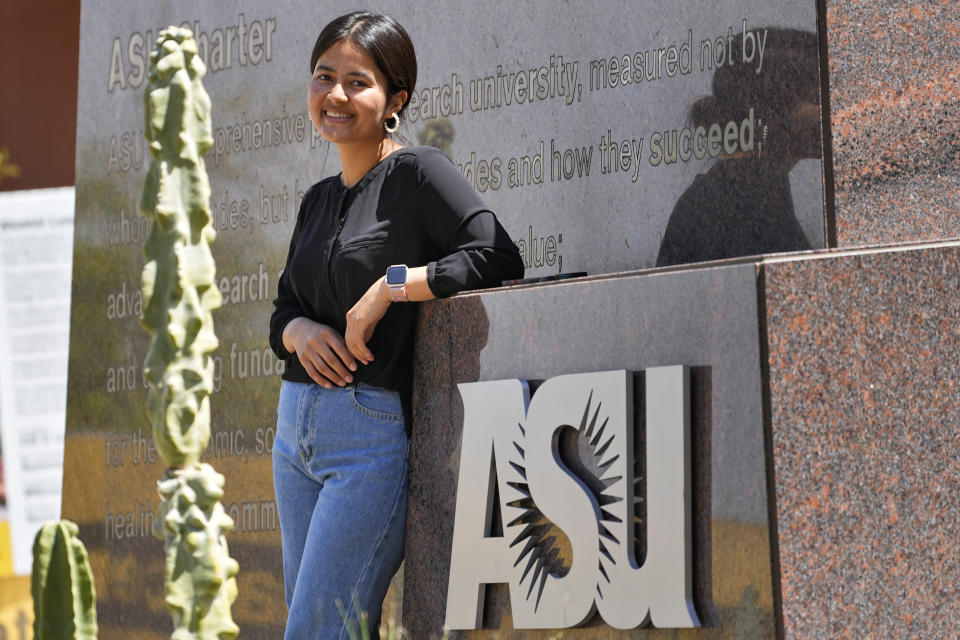 Fahima Sultani stands at the entrance of Arizona State University, Friday, April 7, 2023, in Tempe, Ariz. Sultani and others tried for days in the summer of 2021 to get into the Kabul airport, only to be turned away by the gun-wielding extremists as the Taliban swept back into power. After a harrowing escape, Sultani is one of more than 60 Afghan women who arrived at ASU in December 2021. (AP Photo/Matt York)