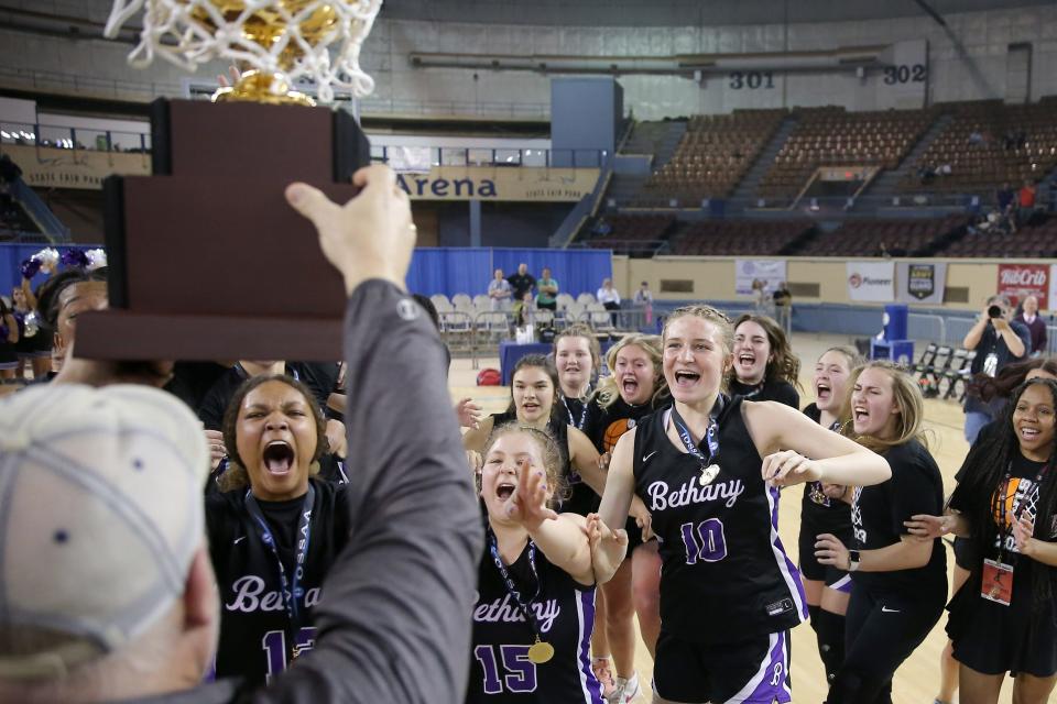 Bethany runs to collect their trophy after the Class 4A girls state basketball championship between Bethany and Lincoln Christian at the State Fair Arena in Oklahoma City, Saturday, March 11, 2023.
