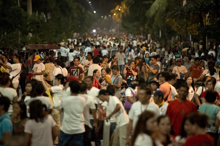 Filipino Catholics gather after Pope Francis' motorcade passed by in Manila on January 15, 2015