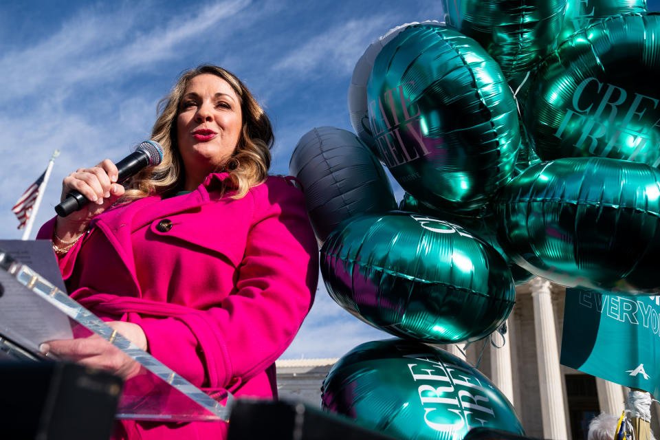 Smith speaks into a microphone outside the Supreme Court.