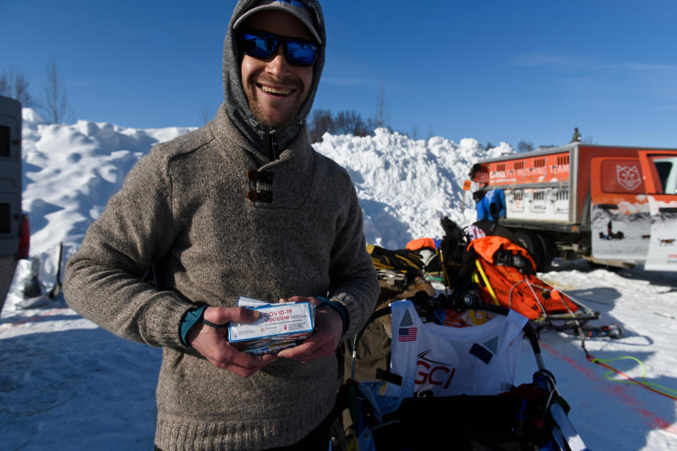 FILE - In this March 7, 2021, file photo, Larry Daugherty, a musher from Eagle River, will carry empty packages of COVID-19 vaccine with him on the trail this year as mushers began the Iditarod Sled Dog Race from the start area at Deshka Landing in Willow, Alaska. Alaska has dropped restrictions on who can get a COVID-19 vaccination, opening eligibility to anyone 16 or older who lives or works in the state in a move that Gov. Mike Dunleavy said could help Alaska's pandemic-battered economy. The Republican, who highlighted his own bout with COVID-19 in making the announcement Tuesday, March 9, 2021, said Alaska is the first U.S. state to remove eligibility requirements. (Marc Lester/Anchorage Daily News via AP, Pool)