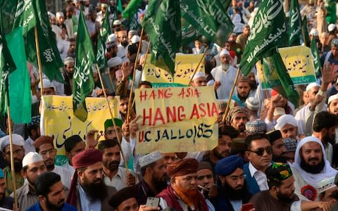 Supporters of Tehreek-e-Labaik Ya Rasool Allah, a hardline religious party, march during a protest in Lahore on October 19, 2018, demanding for hanging to a blasphemy convict Christian woman Asia Bibi, who is on death row.  - Credit: AFP