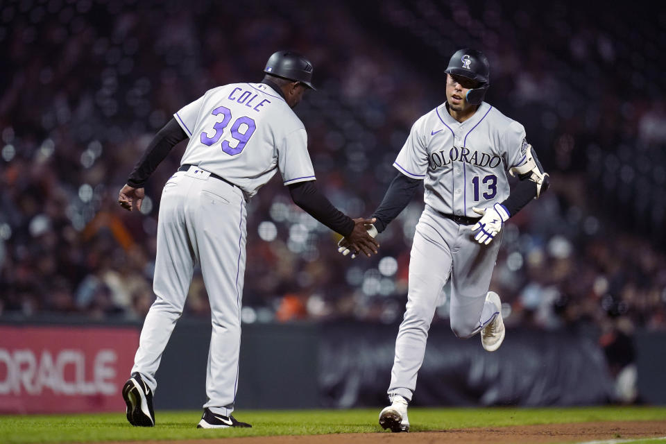 Colorado Rockies' Alan Trejo, right, celebrates with third base coach Stu Cole after hitting a solo home run against the San Francisco Giants during the fifth inning of a baseball game in San Francisco, Wednesday, Sept. 28, 2022. (AP Photo/Godofredo A. Vásquez)