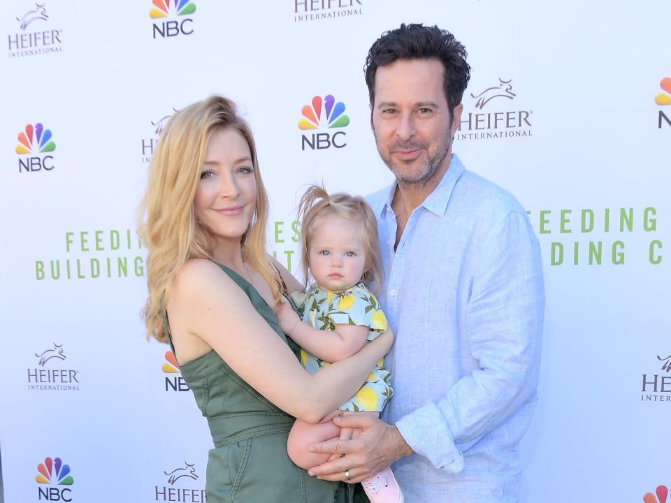 Jennifer Finnigan and Jonathan Silverman hold their daughter.