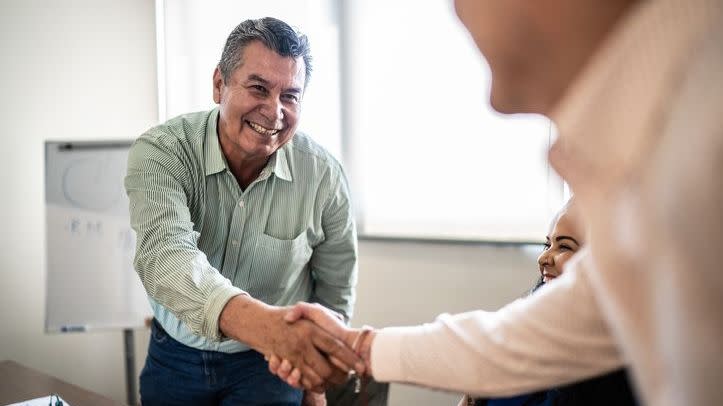 An employee shakes hands with his boss after submitting his retirement letter. 