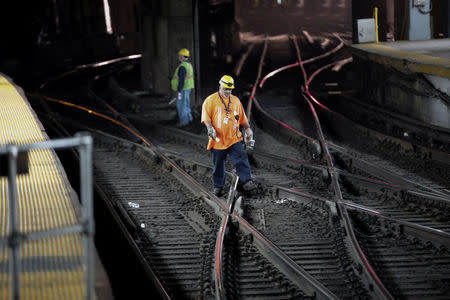 FILE PHOTO: Workers walk on rail tracks inside New York City's Pennsylvania (Penn) Station, U.S. April 27, 2017. REUTERS/Mike Segar/File Photo