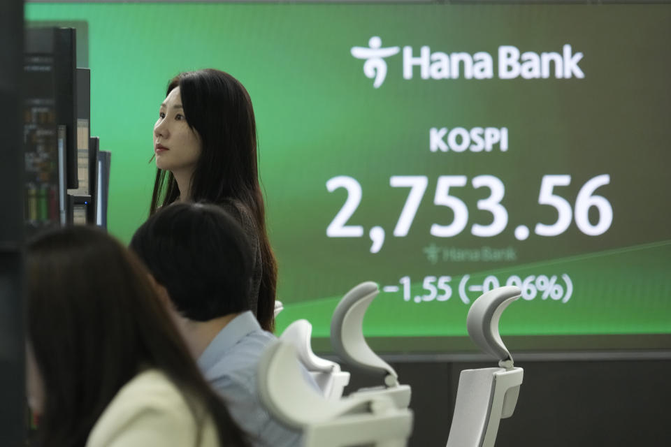 A currency trader watches monitors near a screen showing the Korea Composite Stock Price Index (KOSPI) at the foreign exchange dealing room of the KEB Hana Bank headquarters in Seoul, South Korea, Thursday, March 28, 2024. Asian shares were mixed on Thursday after U.S. stocks broke out of a three-day lull to close at a record. (AP Photo/Ahn Young-joon)