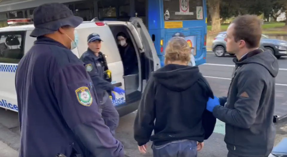 One protester was seen being escorted away by police. Source: Michael Dahlstrom/Yahoo News Australia