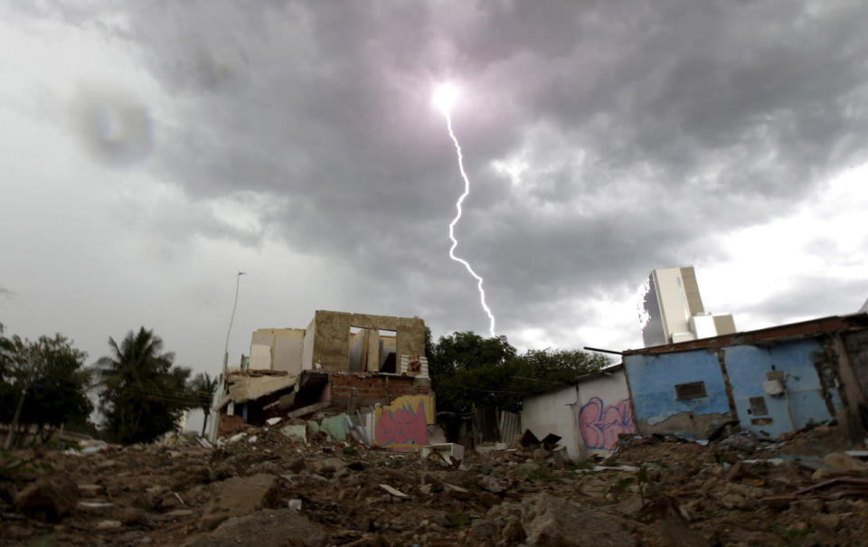 <p>Partially demolished houses stand in the Vila Autodromo slum with the Rio 2016 Olympic Park in the background in Rio de Janeiro, Brazil, February 25, 2016. (REUTERS/Ricardo Moraes)</p>