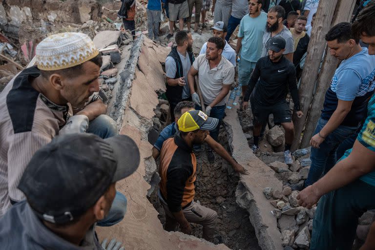 People search the rubble of homes in the mountain village of Imi N'Tala, south of Marrakech, on September 10, 2023. The death toll from Morocco's devastating earthquake has risen to 2,497, the interior ministry said on September 11, as search and rescue efforts continue. (Photo by Matias CHIOFALO / AFP)