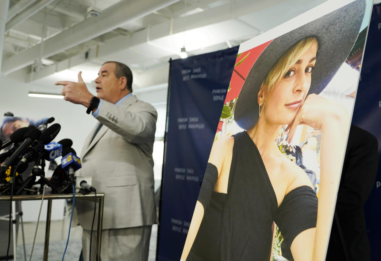 Brian Panish, left, an attorney for the family of late cinematographer Halyna Hutchins, speaks next to a portrait of Hutchins at a news conference, Tuesday, Feb. 15, 2022, in Los Angeles. The family of Hutchins is suing Alec Baldwin and the movie producers of "Rust" for wrongful death, the attorneys said Tuesday. (AP Photo/Chris Pizzello)