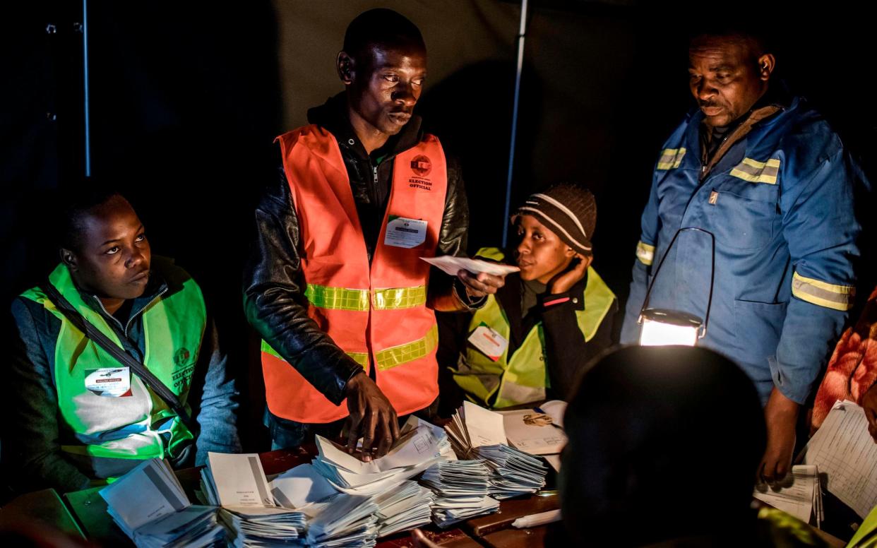 An election official tallies votes at a polling station in the Harare suburb of Mbare - AFP