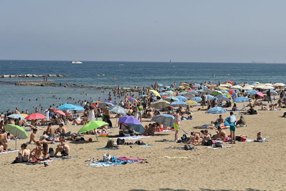 Sunbathers enjoy Barceloneta's beach in Barcelona (AFP via Getty Images)