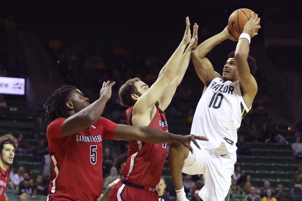 Baylor guard RayJ Dennis (10) attempts to shoot over Gardner-Webb guard Shahar Lazar, center, and forward Ademide Badmus (5) in the first half of an NCAA college basketball game, Sunday, Nov. 12, 2023, in Waco, Texas. (AP Photo/Jerry Larson)