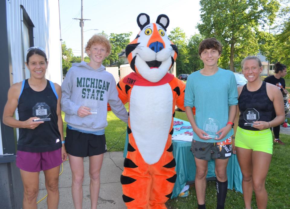 The 10k and the 5k winners of the Cereal City Classic celebrated with Tony the Tiger, including from left, Leslie Scheffers, Aiden Moore, Ethan Saylor and Kayla Kane.