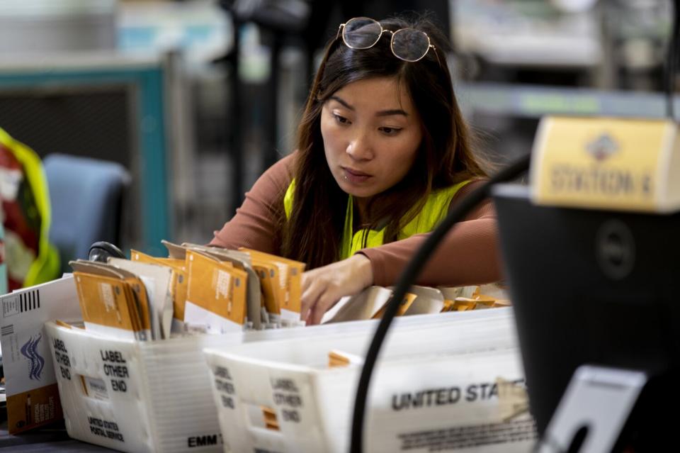 A person looks at a tray of mail.