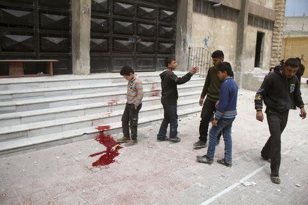 Residents inspect blood stains after what activists said was shelling by warplanes loyal to Syria's president Bashar Al-Assad on Saad Al-Ansari school in Aleppo's rebel-controlled Al-Mashad neighbourhood April 12, 2015. REUTERS/Abdalrhman Ismail