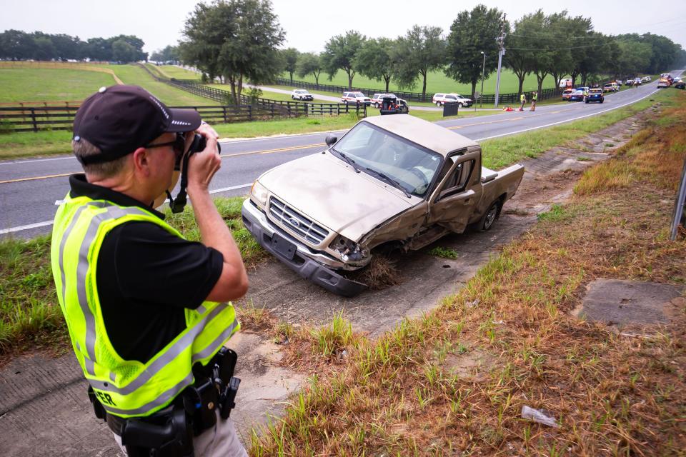 Florida Highway Patrol Cpl. Brett Detweiler takes pictures of the pickup truck that was involved in the Tuesday morning crash in west Marion County.