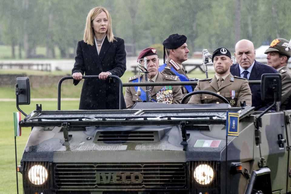 FILE - Italian Premier Giorgia Meloni stands on a military jeep flanked by the Italian Army Chief of Staff Carmine Masiello, second from left, and Defense Minister Guido Crosetto, second from right, on the occasion of the celebrations for the 163 years of the Italian Army, in Rome, Friday, May 3, 2024. Meloni's popularity is expected to ensure significant gains for her far-right Brothers of Italy Party in June's European Parliamentary elections, and European Commission President Ursula Von der Leyen, who has exhibited a liking for Meloni, has already floated the notion of bringing her into a coalition if needed. (Mauro Scrobogna/LaPresse via AP, File)