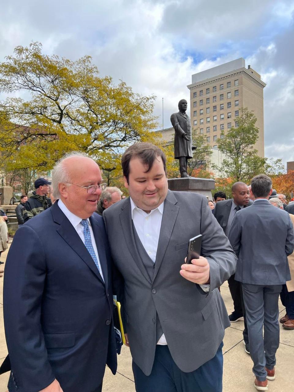 Karl Rove, left, takes a selfie photo with an attendee at the Saturday unveiling of a President William McKinley statue in front of the Stark County Courthouse in downtown Canton. Rove is a former White House official and presidential historian and author.