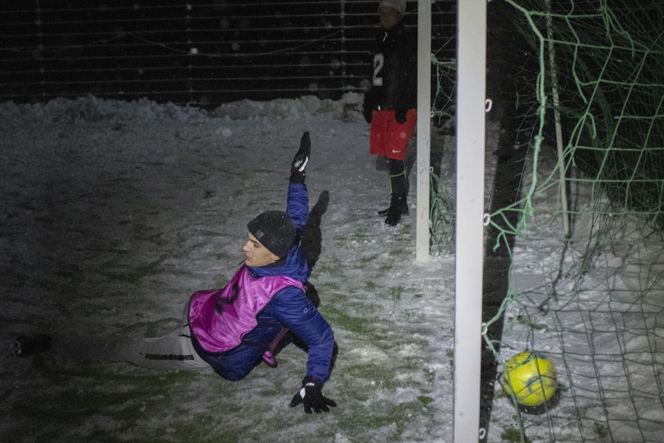 A goal is scored as people play in a soccer game during a blackout in Irpin, Kyiv region, Ukraine, Tuesday, Nov. 29, 2022. For soccer lovers in Ukraine, Russia's invasion and the devastation it has wrought have created uncertainties about both playing the sport and watching it. For Ukrainians these days, soccer trails well behind mere survival in the order of priorities. (AP Photo/Andrew Kravchenko)