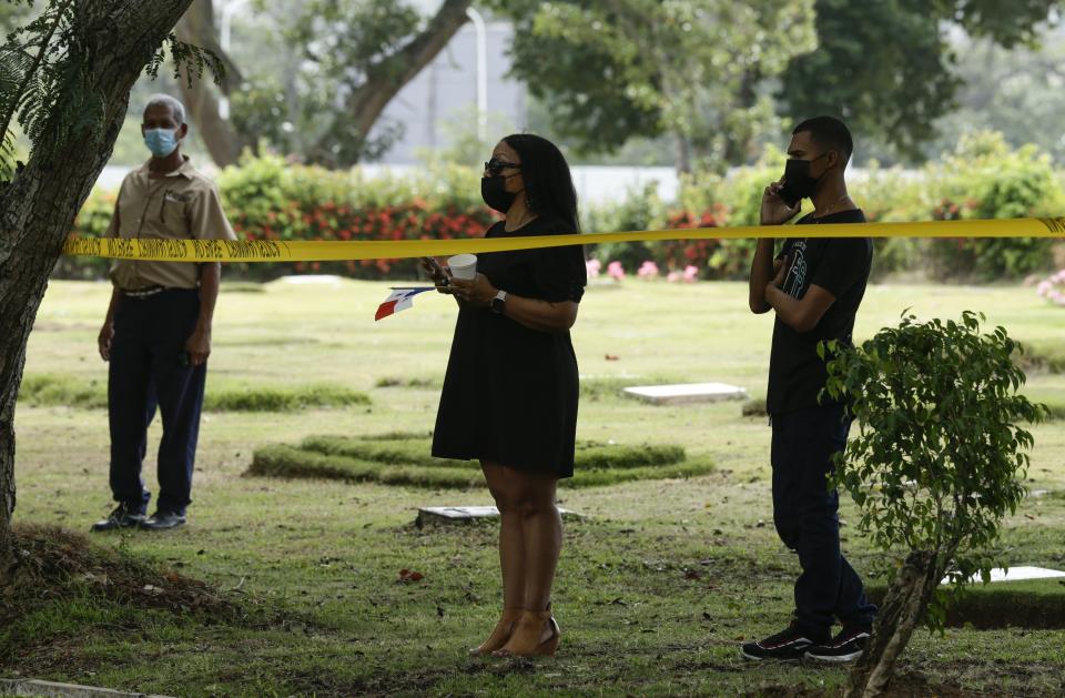Brenda Bethancourt, the daughter of Lt. Braulio Bethancourt, watches as forensic workers exhume what are believed to be the remains of her father, a victim of the 1989 U.S. invasion, at the Jardin de Paz cemetery in Panama City, Thursday, April 15, 2021. The prosecutor’s office has begun an exhumation of human remains at the Panamanian cemetery in a renewed attempt to confirm the identities of the victims of the U.S. invasion. (AP Photo/Arnulfo Franco)