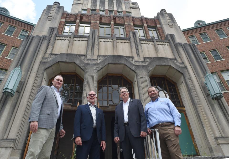 Outside the old St. Mary Academy building Thursday were (from left): Keith Masserant, Michael Bosanac, Monroe Mayor Robert Clark and Mark Cochran.  Masserant's company plans to transform the structure into a place for businesses and homes.