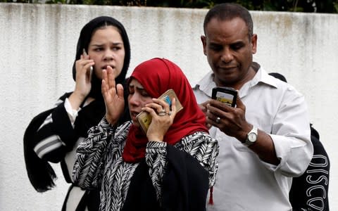 People waiting for news outside a mosque in central Christchurch, New Zealand, following the shooting  - Credit: AP/Mark Baker