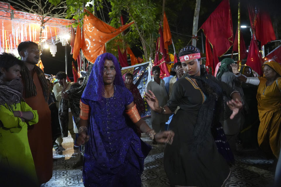 Hindu devotees dance during an annual festival in an cave temple of Hinglaj Mata in Hinglaj in Lasbela district in Pakistan's southwestern Baluchistan province, Friday, April 26, 2024. More than 100,000 Hindus are expected to climb mud volcanoes and steep rocks in southwestern Pakistan as part of a three-day pilgrimage to one of the faith's holiest sites. (AP Photo/Junaid Ahmed)