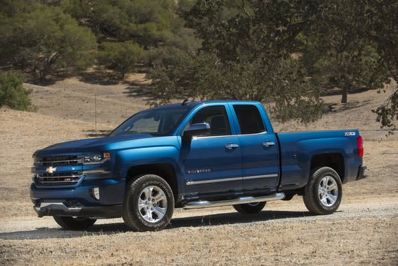 A blue 2017 Chevrolet Silverado pickup parked on a dirt road.