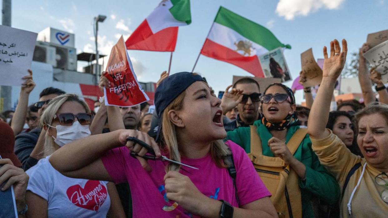 Une manifestante se coupe les cheveux lors d’une manifestation contre le régime iranien et en soutien aux femmes iraniennes, après la mort de la jeune femme iranienne kurde Mahsa Amini, arrêtée à Téhéran par la police des mœurs de la République islamique, à Istanbul le 2 octobre 2022. - Le 2 octobre, des centaines de manifestants sont descendus dans les rues de Turquie pour condamner la répression iranienne des manifestations de femmes, qui a fait au moins 92 morts, suite à la mort d’une jeune femme après son arrestation par la fameuse police des mœurs du pays. L’Iranienne kurde Amini, 22 ans, a été déclarée morte le 16 septembre après avoir été arrêtée pour avoir prétendument enfreint les règles imposant aux femmes de porter le hijab et des vêtements modestes, ce qui a déclenché la plus grande vague d’agitation populaire en Iran depuis près de trois ans. (Photo par Bulent KILIC / AFP)