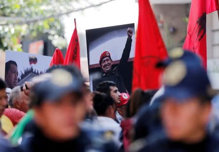 Supporters of Venezuelan President Nicolas Maduro hold pictures of Venezuela's late president Hugo Chavez during an event in favor of Venezuela's Constituent Assembly election, outside Venezuela's embassy in Mexico City, Mexico July 30, 2017. REUTERS/Henry Romero