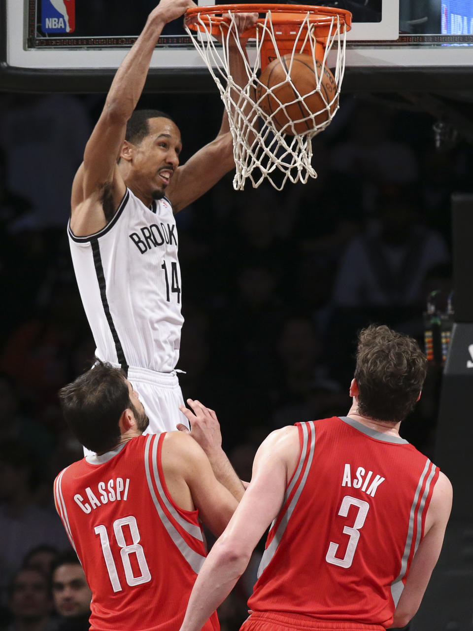 Brooklyn Nets guard Shaun Livingston (14) dunks as Houston Rockets forward Omri Casspi (18) and center Omer Asik (3) look on during the second half of their NBA basketball game at the Barclays Center, Tuesday, April 1, 2014, in New York. (AP Photo/John Minchillo)