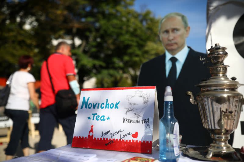 People pass a mock offer of "Novichok Tea" outside the Russian embassy in Berlin