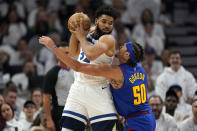 Minnesota Timberwolves center Karl-Anthony Towns is defended by Denver Nuggets forward Aaron Gordon (50) during the first half of Game 3 of an NBA basketball first-round playoff series Friday, April 21, 2023, in Minneapolis. (AP Photo/Abbie Parr)