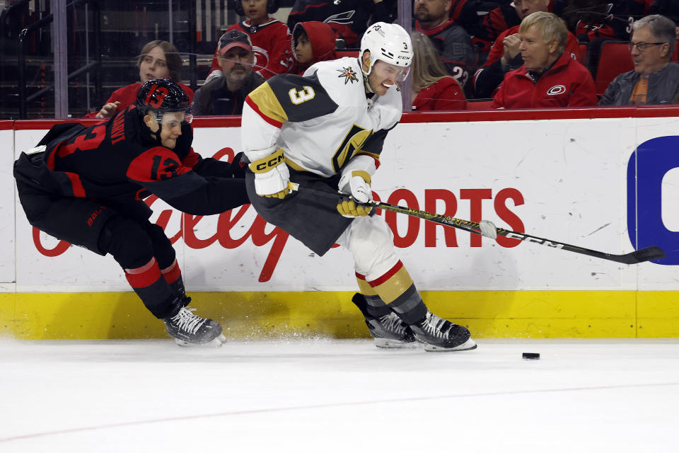 Vegas Golden Knights' Brayden McNabb (3) protects the puck from Carolina Hurricanes' Jesse Puljujarvi (13) during the second period of an NHL hockey game in Raleigh, N.C., Saturday, March 11, 2023. (AP Photo/Karl B DeBlaker)