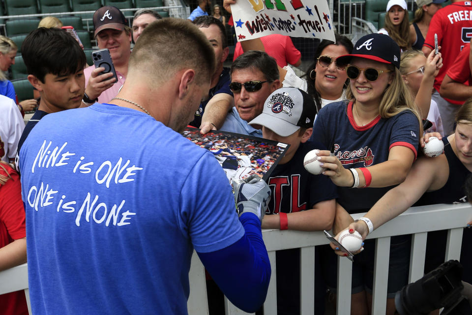 Los Angeles Dodgers first baseman Freddie Freeman (5) signs autographs for fans before the start of a baseball game against the Atlanta Braves Friday, June 24, 2022 in Atlanta. (AP Photo/Butch Dill)